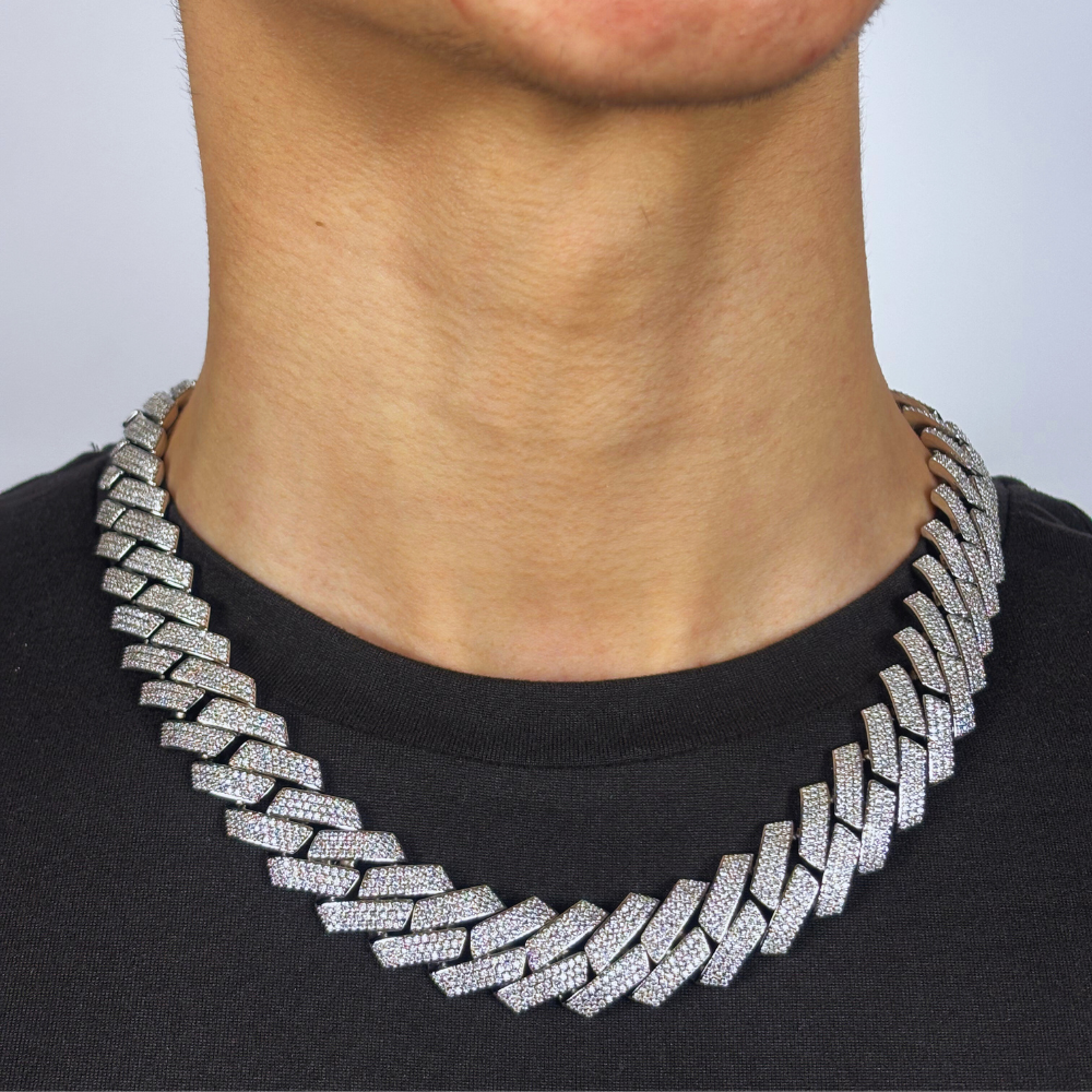 Modelo apresenta o colar 19mm Diamond Prong Link Chain em ouro branco, com elos cuidadosamente trabalhados e adornados com diamantes, criando um brilho deslumbrante e sofisticado. O design refinado e moderno em ouro branco adiciona um toque de luxo e elegância, perfeito para ocasiões especiais ou para complementar um estilo sofisticado.