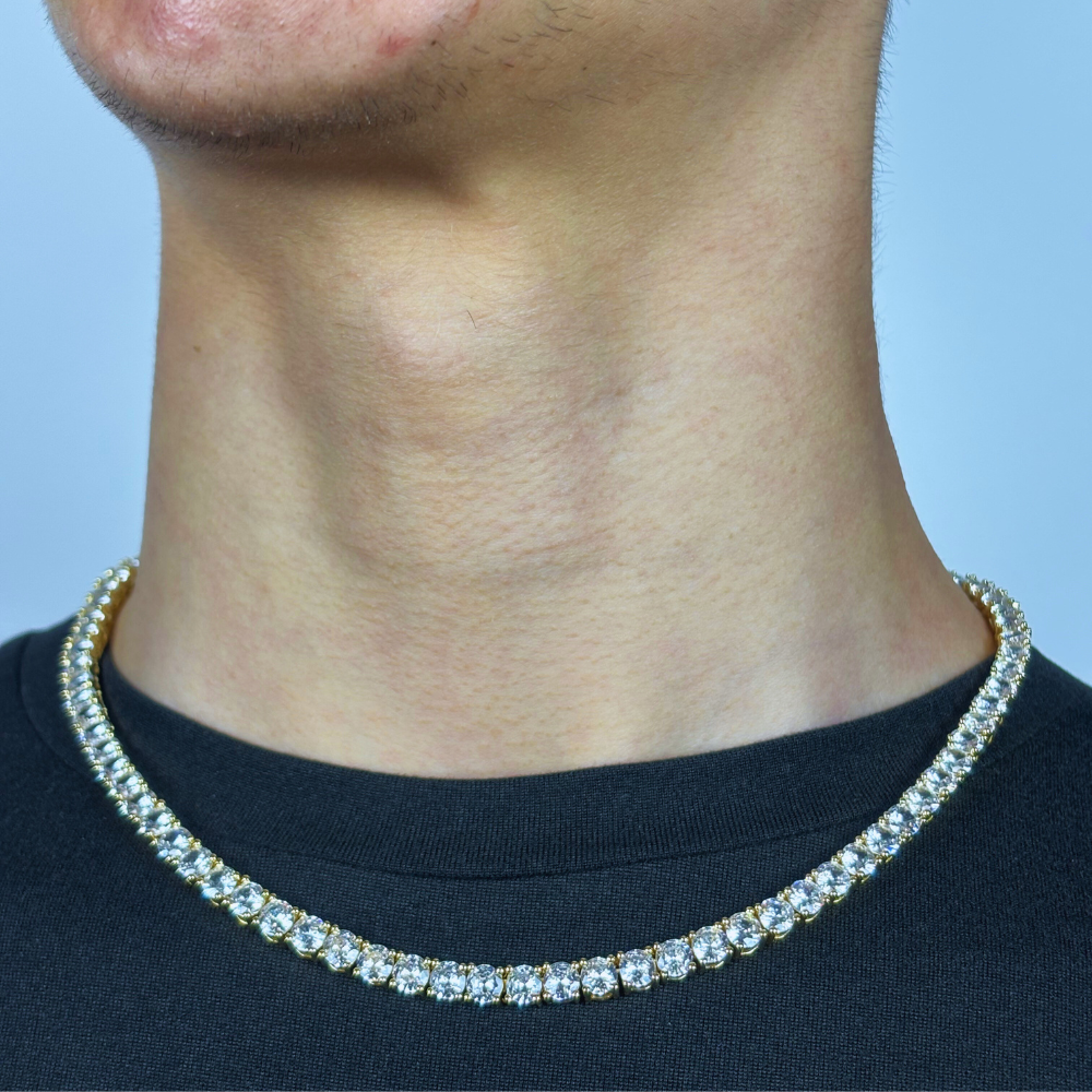 Modelo a apresentar o colar 5mm Tennis Chain em ouro, com zircônias brilhantes dispostas ao longo da corrente, criando um visual elegante e sofisticado. O design delicado e o acabamento em ouro proporcionam um toque de luxo discreto, perfeito para complementar qualquer look com um brilho sutil e refinado.